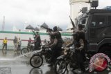Aparat kepolisian bersenjata laras panjang berupaya membubarkan massa perusuh saat simulasi penanganan kerusuhan Pilkada Aceh di Banda Aceh, Aceh, Sabtu (22/10). Simulasi tersebut dilaksanakan untuk meningkatkan kesiapan aparat keamanan dalam menghadapi berbagai kemungkinan gangguan pada pilkada serentak 2017 mendatang. ANTARA FOTO/Ampelsa/kye/16