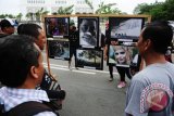 Sejumlah warga melihat foto-foto jurnalistik yang ditampilkan dalam Pameran Foto bertajuk 