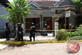 Personel Brimob menjaga rumah terduga anggota jaringan teroris, Gatot Witono saat dilakukan penggeledahan oleh tim Densus 88, di Magetan, Jawa Timur, Selasa (25/10). Tim Densus 88 menangkap terduga teroris, Gatot Witono dilanjutkan penggeledahan dan menyita sejumlah barang bukti di rumahnya. ANTARA FOTO/Siswowidodo/wdy/16