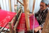 Perajin merenda tenun di rumah kerajinan tenun ikat bukan mesin di Trenggalek, Jawa Timur, Selasa (25/10). Produk kerajinan tenun ikat yang dibuat menggunakan peralatan tradisional itu dijual mulai Rp150 ribu hingga Rp600 ribu, menyesuaikan bahan benang kain yang digunakan.  Antara Jatim/Destyan Sujarwoko/zk/16