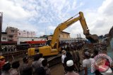 Petugas PT KAI membongkar rumah warga ketika berlangsungnya penertiban bangunan yang terletak di kawasan pinggiran rel Jalan Timah Medan, Sumatera Utara, Rabu (26/10). PT KAI Divre I Sumut membongkar bangunan yang berdiri di sisi rel untuk pembangunan jalur rel ganda kereta api dari stasiun besar Kereta Api Medan - Araskabu dan menuju Bandara Kualanamu. ANTARA SUMUT/Septianda Perdana/16