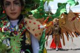 Peserta pawai mengenakan busana karnaval melintas saat mengikuti pawai budaya di Kota Madiun, Jawa Timur, Minggu (30/10). Ratusan orang peserta mengikuti pawai budaya dalam rangka memeriahkan tahun baru Hijriyah. Antara Jatim/Foto/Siswowidodo/zk/16