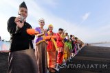 Sejumlah pemuda pemudi mengenakan baju adat daerah saat pelepasan anak penyu (tukik) di Pantai Boom, Banyuwangi, Jawa Timur, Sabtu (29/10). Kegiatan pelepasliaran 245 ekor tukik yang melibatkan pelajar, suku,etnis dan tokoh lintas agama tersebut, guna memperingati hari Sumpah Pemuda sekaligus mengajak pelajar dan masyarakat dalam pelestarian lingkungan terutama penyu. Antara jatim/Budi Candra Setya/zk/16.