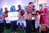 Direktur Utama PT Indocement Tunggal Prakarsa Tbk, Christian Kartawijaya (dua kiri) menyerahkan penghargaan kepada juara The Quarry Life Award National Awarding ke-3 tahun 2016, di Bogor Jawa Barat, Kamis malam (03/11). Wakil dari Universitas Gadjah Mada (UGM) Yogyakarta diwakili Siti Nurlely Marliana meraih juara pertama nasional kompetisi ilmiah di bidang pendidikan 'Quarry Life Award' 2016 tersebut. (ANTARA FOTO/M.Tohamaksun/).