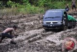 Sebuah mobil terperangkap di jalan yang berkubang lumpur di kilometer 46 Lenggo, Kabupaten Kutai Timur. Jalan rusak di kawasan Lenggu, Kabupaten Kutai Timur sepanjang 13 kilometer tersebut merupakan salah salah jalur distribusi kebutuhan pokok ke pedalaman dan pelosok di Kabupaten Berau    (Amirullah/ANTARA)
