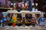 Perajin menyelesaikan kerajinan miniatur boneka berpakaian adat Nusantara di Sidoarjo, Jawa Timur, Senin (7/11). Kerajinan tersebut mengambil 34 pakaian adat nusantara dan dijual per buah maupun per pasang dengan harga Rp60.000 sampai Rp500.000. Antara Jatim/Umarul Faruq/16