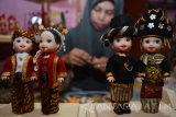 Perajin menyelesaikan kerajinan miniatur boneka berpakaian adat Nusantara di Sidoarjo, Jawa Timur, Senin (7/11). Kerajinan tersebut mengambil 34 pakaian adat nusantara dan dijual per buah maupun per pasang dengan harga Rp60.000 sampai Rp500.000. Antara Jatim/Umarul Faruq/16