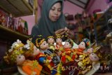 Perajin menyelesaikan kerajinan miniatur boneka berpakaian adat Nusantara di Sidoarjo, Jawa Timur, Senin (7/11). Kerajinan tersebut mengambil 34 pakaian adat nusantara dan dijual per buah maupun per pasang dengan harga Rp60.000 sampai Rp500.000. Antara Jatim/Umarul Faruq/16