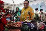 Menteri Koperasi dan UKM Anak Agung Gede Ngurah Puspayoga (kanan) saat meninjau salah satu stan pameran Tanggulangin Fair 2016 di lapangan Kedensari, Tanggulangin, Sidoarjo, Jawa Timur.  Tanggulangin Fair 2016 merupakan pameran produk unggulan para pelaku Usaha Kecil dan Menengah (UKM) dan sarana promosi produk Sidoarjo dalam membangkitkan UKM Tanggulangin. (ANTARA FOTO/Umarul Faruq/Dok).