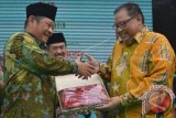 Menteri Koperasi dan UKM Anak Agung Gede Ngurah Puspayoga (kanan) saat menerima cinderamata dari Bupati Sidoarjo Saiful Illah (kiri) pada Tanggulangin Fair 2016 di lapangan Kedensari, Tanggulangin, Sidoarjo, Jawa Timur. Tanggulangin Fair 2016 merupakan pameran produk unggulan para pelaku Usaha Kecil dan Menengah (UKM) dan sarana promosi produk Sidoarjo dalam membangkitkan UKM Tanggulangin. (ANTARA FOTO/Umarul Faruq/Dok).


