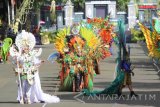 Sejumlah peserta  mengenakan busana kreasinya saat pagelaran Banyuwangi Ethno Carnival (BEC) di Banyuwangi, Jawa Timur, Sabtu (12/11). Pagelaran busana yang bernuansa budaya lokal tersebut merupakan salah satu dari 53  agenda Banyuwangi Festival guna menarik wisatawan. Antara Jatim/Budi Candra Setya/zk/16.