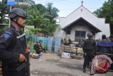 Personel Brimob Polda Kaltim mengamankan lokasi ledakan bom di Gereja Oikumene Kecamatan Loa Janan Ilir, Samarinda, Kalimantan Timur, Minggu (13/11). Ledakan bom tersebut menyebabkan lima orang terluka yang semuanya merupakan masih anak-anak, empat diantaranya mengalami luka bakar parah dan seorang terduga pelaku peledakan berhasil ditangkap warga. (ANTARA FOTO/Amirullah)
