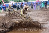 Crosser Yoshua Pattipi (kiri) beradu cepat dengan Crosser Igam Auzan (kanan) dalam putaran kedua Kejurnas Motocross Indonesia 2016 kelas MX2 di sirkuit Pantai Prigi, Trenggalek, Jawa Timur, Sabtu (12/11). Grand Final Kejurnas Motocross Indonesia kelas MX2 itu dimenangi Crosser Andre Sondakh dari tim Djagung Pertamax Racing Dunlop Orca Husky Husqvarna asal Jawa Timursekaligus menyabet juara umum kelas MX2 melahap 14 lap yang dilombakan di sirkuit sepanjang 1.200 meter dengan catatan waktu 29::56,526 detik. Antara Jatim/Destyan Sujarwoko/zk/16