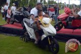 Pengunjung mencoba menaiki motor listrik GESITS saat sosialisasi di Lapangan Bajra Sandhi, Denpasar, Bali, Minggu (13/11). Motor bertenaga listrik karya anak bangsa tersebut disosialisasikan ke masyarakat Pulau Dewata untuk mendukung program 'Bali Clean and Green' menyusul telah ditetapkannya Bali sebagai kawasan nasional energi bersih. ANTARA FOTO/Wira Suryantala/wdy/16.