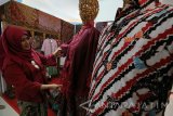 Penjual menata baju batik saat Sparkling Surabaya Tourism Fiesta di Surabaya, Jawa Timur, Minggu (13/11). Berbagai macam kegiatan baik pameran makanan dan non makanan serta hiburan alternatif bagi masyarakat tersebut digelar oleh Fakultas Pariwisata jurusan Hotel and Tourism Business Universitas Ciputra bekerjasama dengan PT Pelindo III. Antara jatim/Didik Suhartono/zk/16