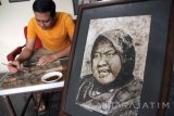 Seniman melukis dengan bahan dasar cethe atau endapan bubuk kopi di rumah galeri seni di Tulungagung, Jawa Timur, Kamis (17/11). Karya seni lukis cethe itu dijual dengan harga di kisaran Rp1 juta hingga Rp2 juta per buah, menyesuaikan ukuran dan tingkat kerumitan objek gambar. Antara Jatim/Destyan Sujarwoko/zk/16