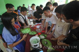 Sejumlah pelajar dari Raffles Institute Singapore belajar membuat kue Klepon saat berkunjung ke SMP Yayasan Pengembangan Pendidikan Indonesia (YPPI) I Surabaya, Jawa Timur, Rabu (23/11). Kegiatan yang diikuti oleh 20 pelajar dari Raffles Institute Singapore tersebut dalam rangka pertukaran pelajar yang bertujuan untuk mengenalkan budaya Indonesia sekaigus menjalin persahabatan antara pelajar Indonesia dan Singapura. Antara Jatim/Moch Asim/zk/16