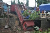 Warga menyaksikan truk gandeng yang mengalami kecelakaan di Jalan Pantura Desa Ngembalrejo, Kudus, Jawa Tengah, Rabu (23/11). Truk yang melaju dari arah Surabaya menuju Cirebon tersebut mengalami kecelakaan karena sopir mengantuk dan mengakibatkan sopir dan kernet mengalami luka ringan dan sebuah kios rusak. ANTARA FOTO/Yusuf Nugroho/aww/16.