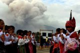 Sejumlah anak-anak pengungsi Sinabung membawakan tarian tradisional suku Karo pada pembukaan pameran foto "Kembali Untuk Sinabung" di Desa Ndokum Siroga Kabupaten Karo, Sumatra Utara, Sabtu (12/11). Pameran foto yang diikuti fotografer yang tergabung dalam Pewarta Foto Indonesia (PFI) Medan itu menggambarkan tentang peristiwa erupsi Gunung Sinabung yang hingga kini masih terus terjadi. ANTARA SUMUT/Septianda Perdana/16