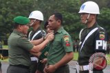 Kasdam I Bukit Barisan Brigjen TNI Tiopan Aritonang (kiri) secara simbolis melepaskan seragam Praka Agus Alosius Purba sebagai bentuk pemecatan secara tidak hormat kepada anggota TNI, di Lapangan Benteng Medan, Sumatra Utara, Senin (7/11). Kodam I Bukit Barisan melakukan pemecatan terhadap 47 anggota TNI dan 11 orang di antaranya terlibat dalam penyalahgunaan narkoba serta tindak pidana disersi. ANTARA SUMUT/Septianda Perdana/16 