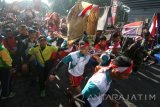 Sejumlah pemuda membawa repelika tandu saat peringatan napak tilas rute perjuangan gerilya Jenderal Soedirman ke-35 bertajuk 'Soedirman Trail Run' di Kediri, Jawa Timur, Sabtu (26/11). Kegiatan tahunan yang diikuti oleh sedikitnya dua ribu peserta tersebut menempuh jarak kurang lebih 45 km dengan finish di Desa Bajulan Kabupaten Nganjuk. Antara Jatim/Prasetia Fauzani/zk/16