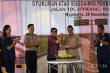 Direktur PT Astra International Paulus Bambang (tengah) memberikan potongan tumpeng kepada Wakil Bupati Mojokerto Pungkasiadi (dua kanan) saat syukuran selesainya pembangunan ruas tol Jombang - Mojokerto seksi 3 di Desa Pagerluyung, Mojokerto, Jawa Timur, Senin (28/11). Ruas tol Jombang - Mojokerto seksi 3 sepanjang 5 kilometer itu dapat dilalui untuk uji coba pada 1 Desember mendatang dan akan tersambung dengan seksi 4 ruas tol Surabaya - Mojokerto. Antara Jatim/Syaiful Arif/zk/16