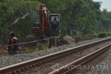 Pekerja melakukan pekerjaan menggunakan alat berat untuk mengeruk dan meratakan tanah di lokasi proyek pembangunan jalur ganda (double track) rel Kereta Api (KA) Jombang-Madiun di kawasan Kartoharjo, Kota Madiun, Jawa Timur, Selasa (29/11). Pembangunan jalur ganda KA Jawa lintas selatan segmen Jombang-Madiun sepanjang 84 kilometer diperkirakan menghabiskan anggaran sekitar Rp590 miliar. Antara Jatim/Foto/Siswowidodo/zk/16