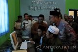 Menteri Agama Republik Indonesia Lukman Hakim Saifuddin (kanan) meluncurkan aplikasi iSantri Digital Centre di Pondok Pesantren Salafiyah Syafiiyah Sukorejo, Banyuputih, Situbondo, Jawa Timur, Senin (28/11). iSantri merupakan aplikasi sosial media berbasis buku, kitab digital yang berisi beragam kitab, buku pelajaran, buku sains dan buku penunjang lainnya yang bisa dipinjam dan dibaca oleh santri untuk belajar selama di pondok, guna meningkatkan keilmuan dan wawasan para santri. Antara Jatim/Seno/zk/16.