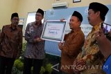 Menteri Agama Republik Indonesia Lukman Hakim Saifuddin (kedua kiri) meluncurkan aplikasi iSantri Digital Centre di Pondok Pesantren Salafiyah Syafiiyah Sukorejo, Banyuputih, Situbondo, Jawa Timur, Senin (28/11). iSantri merupakan aplikasi sosial media berbasis buku, kitab digital yang berisi beragam kitab, buku pelajaran, buku sains dan buku penunjang lainnya yang bisa dipinjam dan dibaca oleh santri untuk belajar selama di pondok, guna meningkatkan keilmuan dan wawasan para santri.Antara Jatim/Seno/zk/16