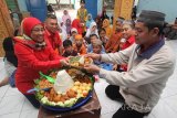 Executive Vice President Telkomsel Area Jawa Bali Ririn Widaryati (kiri) memberikan potongan tumpeng kepada Ketua Yayasan Panti Asuhan Ar Rochim Nur Ikhyak (kanan) saat berkunjung ke panti asuhan tersebut di Surabaya, Jawa Timur, Senin (28/11). Telkomsel menggelar program berbagi berkah dan berdoa (BERANDA) dengan 1001 anak yatim piatu di 36 panti asuhan di wilayah Jawa dan Bali secara serentak sebagai bentuk kepedulian dan rasa syukur atas pencapaian di penghujung tahung 2016. Antara Jatim/Moch Asim/zk/16
