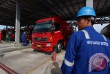 Petugas Pertamina bekerja menggunakan sistem pengontrol otomatis penyaluran BBM atau New Gantry System (NGS) pada truk tangki BBM di Terminal Bahan Bakar Minyak (TBBM) Medan, Sumatera Utara, Jumat (25/11). PT Pertamina menerapkan sistem pengontrol secara otomatis atau disebut "New Gantry System" (NGS) sebagai upaya modernisasi fasilitas pendistribusian BBM perusahaan untuk memberikan layanan dengan kualitas yang lebih baik dan cepat dalam menekan angka kehilangan (losses) dan kebocoran bahan bakar minyak dari operasional penerimaan, penimbunan, dan penyaluran ke dalam truk tangki distribusi BBM. ANTARA SUMUT/Septianda Perdana/16
