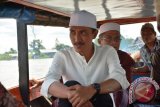 Wakil Bupati Banjar H Saidi Mansyur menemui warganya yang berada dipinggiran sungai saat menghadiri perayaan Maulidur Rasul Muhammad SAW menggunakan klotok atau perahu kayu bermesin di Desa Paku Alam Kecamatan Sungai Tabuk, minggu (4/12). 