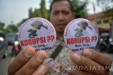 Petugas Kejaksaan Tinggi Sidoarjo menunjukan pin yang akan dibagikan kepada pengguna jalan ketika melakukan aksi memperingati Hari Anti Korupsi Internasional di Sidoarjo, Jawa Timur, Jumat (9/12). Pembagian pin dan stiker tersebut merupakan salah satu bentuk memperingati Hari Anti Korupsi. Antara Jatim/Umarul Faruq/zk/16