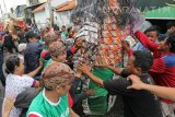 Warga berebut gunungan saat pawai Maulid Nabi di kawasan Rangkah,  Surabaya, Jawa Timur, Senin (12/12). Pawai yang diikuti ratusan warga Surabaya tersebut untuk memperingati hari lahir Nabi Muhammad SAW. Antara Jatim/Didik Suhartono/zk/16