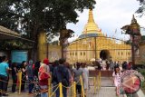 Pengunjung memasuki halaman replika Pagoda Shwedagon Taman Alam Lumbini, Karo, Sumatera Utara, Senin (12/12). Replika Pagoda Shwedagon Myanmar tersebut merupakan pagoda tertinggi di Indonesia dan menjadi salah satu objek wisata religi di Sumatera Utara. ANTARA SUMUT/Septianda Perdana/16