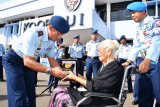 Panglima Koopsau I Marsekal Muda TNI Yuyu Sutisna memberikan cinderamata kepada Ibu Hastoeti Basuki, adik Kadung dari Kapten Udara (Anumerta) Harry Hadisoemantri. (Foto Istimewa)