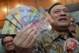 Gubernur Bank Indonesia (BI) Agus Martowardojo menunjukkan uang rupiah kertas dan logam tahun emisi 2016 seusai peluncurannya di Gedung Bank Indonesia, Jakarta, Senin (19/12). Uang rupiah yang diluncurkan antaralain Rp100.000 (gambar utama Ir Soekarno dan Moh. Hatta), Rp50.000 (gambar utama Ir. H. Djuanda Kartawidjaya), Rp20.000 (gambar utama G.S.S.J Ratulangi), Rp10.000 (gambar utama Frans Kaisiepo), Rp5.000 (gambar utama K.H Idham Chalid), Rp2.000 (gambar utama Mohammad Hoesni Thamrin) dan Rp1.000 (gambar utama Tjut Meutia), pecahan logam, mulai dari Rp1.000 (gambar utama I Gusti Ketut Pudja), Rp500 (gambar utama Letjend TNI T.B Simatupang), Rp200 (gambar utama Tjiptomangunkusumo) dan Rp100 (gambar utama Herman Johannes). ANTARA FOTO/Yudhi Mahatma/aww/16.