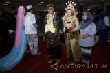 Seorang pengantin di rias saat mengikuti prosesi nikah massal di Surabaya, Jawa Timur, Rabu (21/12). Nikah massal yang diikuti 100 pasangan pengantin berbagai usia dari keluarga kurang mampu tersebut diselenggarakan sebagai upaya mengedukasi masyarakat mengenai pentingnya menikah secara resmi yang tercatat oleh negara. Antara Jatim/Umarul Faruq/zk/16