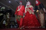 Sejumlah pasangan mengikuti pawai prosesi nikah massal di Surabaya, Jawa Timur, Rabu (21/12). Nikah massal yang diikuti 100 pasangan pengantin berbagai usia dari keluarga kurang mampu tersebut diselenggarakan sebagai upaya mengedukasi masyarakat mengenai pentingnya menikah secara resmi yang tercatat oleh negara. Antara Jatim/Umarul Faruq/zk/16