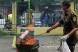 Petugas membakar sejumlah barang bukti saat pemusnahan barang bukti di Kejaksaan Negeri (Kejari) Tanjung Perak, Surabaya, Jawa Timur, Kamis (22/12). Sejumlah barang bukti yang beberapa diantaranya Ganja seberat 10,1 kilogram, Sabu seberat 628 gram dan pil koplo sebanyak 15.221 butir yang dimusnahkan Kejari Tanjung Perak Surabaya tersebut merupakan barang bukti dari perkara sepanjang tahun 2016 oleh putusan pengadilan telah dinyatakan 