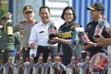 Menteri Keuangan Sri Mulyani (kedua kanan) bersama Kepala BNN Komjen Budi Waseso (kedua kiri), Dirjen Pajak Heru Pambudi (kanan), dan Kapolda Metro Jaya Irjen Pol M. Iriawan (kiri) memegang botol minuman keras tanpa pita cukai di halaman kantor pusat DJBC, Jakarta, Jumat (23/12). Dalam kesempatan tersebut, sebanyak 28.787 botol minuman keras, 510 cerutu, 3,32 juta batang rokok dengan potensi kerugian negara mencapai Rp12,5 miliar dimusnahkan. ANTARA FOTO/Rosa Panggabean/wdy/16.