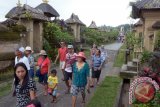Sejumlah wisatawan melintas saat Penglipuran Village Festival 2016 di Desa Wisata Penglipuran, Bangli, Bali, Minggu (25/12). Festival yang digelar setiap tahun tersebut berlangsung pada 22 Desember 2016 hingga 2 Januari 2017 diisi dengan ajang pentas budaya dan lomba-lomba untuk promosikan sekaligus meningkatkan kunjungan wisatawan di daerah itu.ANTARA FOTO/Wira Suryantala/16.