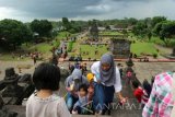 Sejumlah wisatawan domestik (wisdom) berusaha naik ke atas Candi Penataran di Desa Penataran, Kecamatan Nglegok, Kabupaten Blitar, Jawa Timur, Minggu (25/12). Pada musim liburan Natal dan Tahun Baru 2017 jumlah pengunjung Candi Penataran naik dua kali lipat dibandingkan hari biasa. Antara Jatim/Foto/Slamet Agus Sudarmojo/zk/16.   