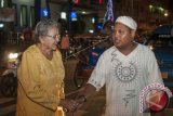 Umat Kristiani Ibu Telussa (kiri) berjabat tangan sambil mengucapkan terima kasih kepada salah satu pemuda Muslim, Ewin (kanan) yang membantu menjaga gereja serta mengatur arus lalu lintas saat umat Kristiani beribadah malam Natal di Gereja Silo, Ambon, Maluku, Sabtu (24/12) malam. Pemuda Muslim dari sejumlah kelompok Remaja Masjid di Kota Ambon, berpartisipasi menjaga gereja, saat warga Kristen Kota Ambon melaksanakan ibadah malam Natal, sebagai wujud toleransi sesuai falsafah 