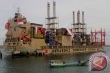 Sebuah perahu melintas di samping Kapal Listrik asal Turki 'Marine Vessel Power Plant' di PLTU Bolok Kupang, NTT, Rabu (28/12). Kapal listrik berkapasitas 120 Megawatt tersebut telah resmi beroperasi dengan daya 36 MW dan akan dilakukan peningkatan secara bertahap sampai dengan 60 MW sesuai kontrak antara PT. PLN dengan pihak kapal. ANTARA FOTO/Kornelis Kaha/wdy/16.