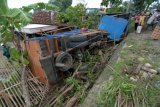 Warga memperhatikan truk yang terguling di Desa Larangan Tokol, Pamekasan, Jawa Timur, Rabu (28/12). Truk dengan muatan pasir itu terguling dan menimpa rumah warga setelah berusaha meninghindari kendaraan dari arah beralwanan. Tidak. ANTARA FOTO/Saiful Bahri/Spt/16