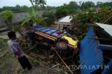 Warga melihat truk yang terguling di Desa Larangan Tokol, Pamekasan, Jawa Timur, Rabu (28/12). Truk dengan  muatan pasir itu terguling dan menimpa rumah warga setelah meninghindari kendaraan dari arah beralwanan. Tidak ada korban jiwa dalam kejadian ter sebut. Antara Jatim/Saiful Bahri/zk/16