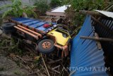 Warga melihat truk yang terguling di Desa Larangan Tokol, Pamekasan, Jawa Timur, Rabu (28/12). Truk dengan  muatan pasir itu terguling dan menimpa rumah warga setelah meninghindari kendaraan dari arah beralwanan. Tidak ada korban jiwa dalam kejadian ter sebut. Antara Jatim/Saiful Bahri/zk/16
