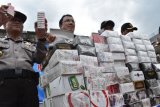 Petugas menunjukkan barang bukti rokok illegal hasil sitaan sebelum dimusnahkan di halaman Kantor Pengawasan dan Pelayanan Bea dan Cukai (PPBC) Madiun, Jawa Timur, Kamis (29/12). Kantor PPBC Madiun memusnahkan  35.830 batang rokok, 173 botol minuman beralkohol, 108 bungkus tembakau iris hasil operasi selama 2016. Antara Jatim/Siswowidodo/zk/16