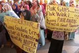 Sejumlah guru kontrak dari SD dan SMP yang tergabung dalam Barisan Guru Bersatu Aceh membentangkan poster saat aksi di kantor gubernur Aceh, Banda Aceh, Jumat (30/12). Mereka mendesak pemerintah pusat dan pemerintah Aceh mengalokasikan dana untuk guru kontrak yang terancam putus kontrak, serta menolak keras implementasi UU nomor 23 tahun 2014 jika bertujuan memisahkan pengelolaan dan penyelenggaraan pendidikan dasar oleh pemerintah kota dan provinsi. ANTARA FOTO/Ampelsa/foc/16.